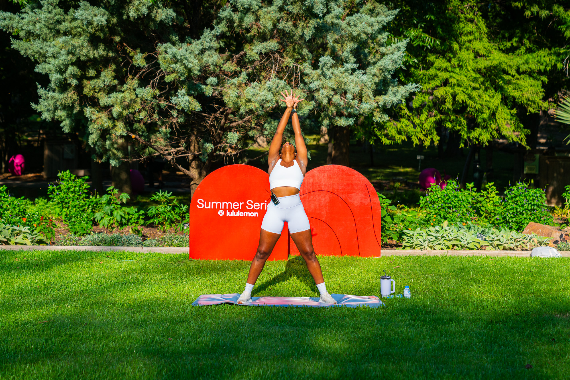 The instructor leading a pose in front of the Summer Series signs
