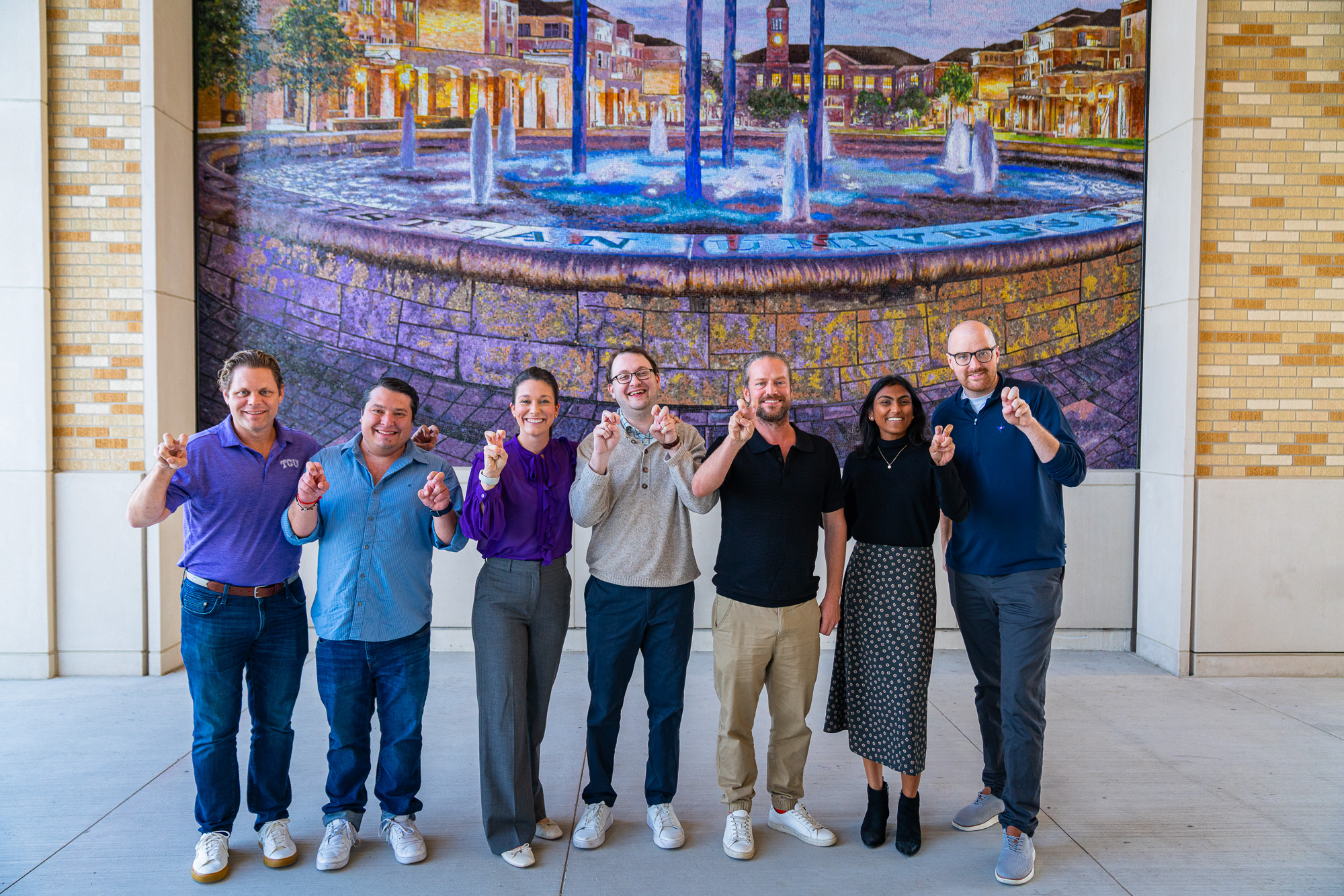 The Techstars cohort posing in front of the fountain mural at TCU