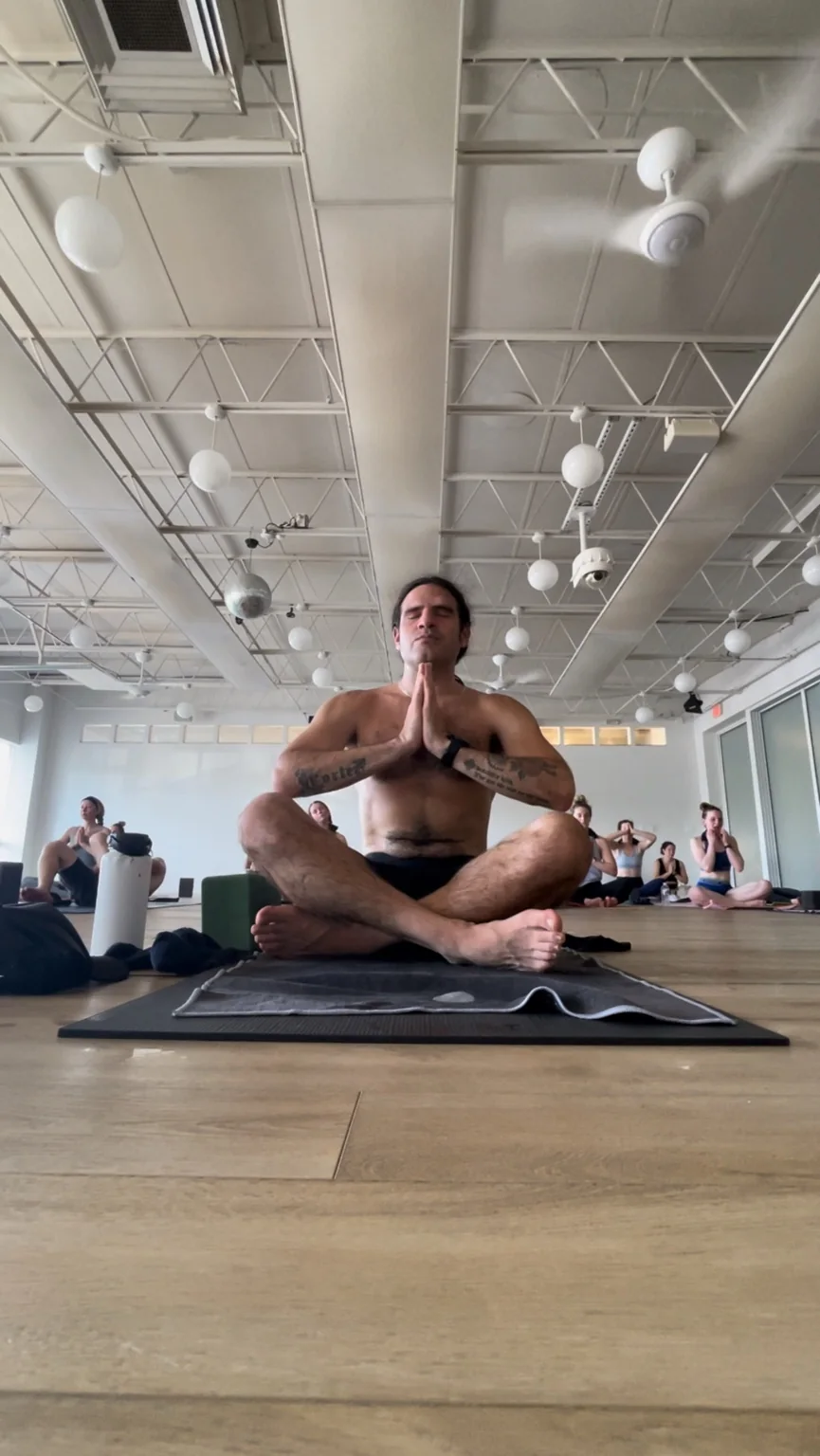 Gregory seated in a yoga class
